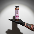 Transparent Fuel Bottled Trail Mix in Cherry Walnut flavor on a tattoo artist's hand with an American flag tattoo