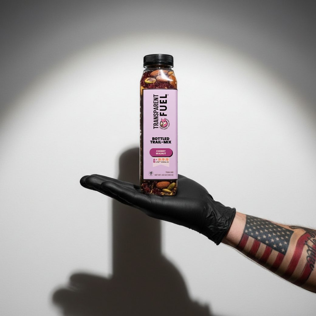 Transparent Fuel Bottled Trail Mix in Cherry Walnut flavor on a tattoo artist's hand with an American flag tattoo